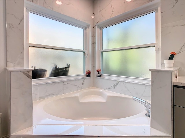 full bathroom with vanity and a bath