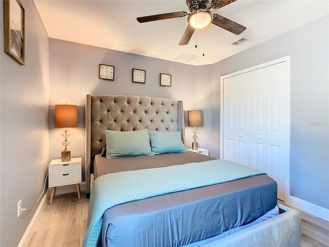 bedroom featuring baseboards, visible vents, ceiling fan, and light wood finished floors