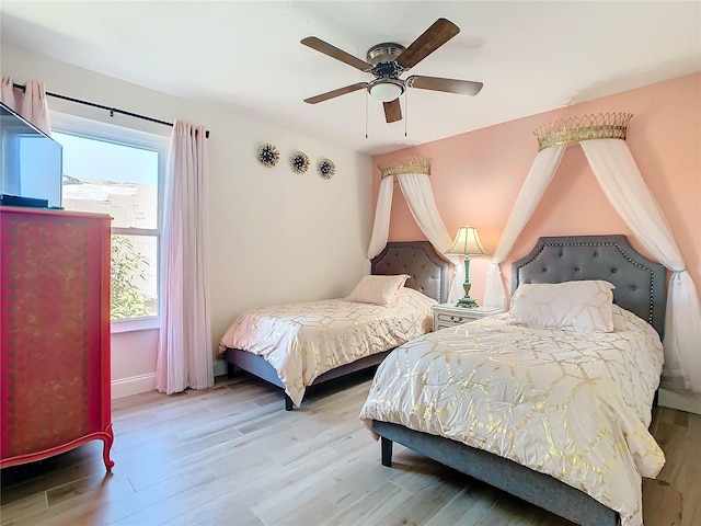 bedroom featuring ceiling fan, light wood finished floors, and baseboards