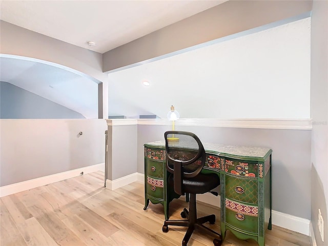 home office featuring vaulted ceiling, baseboards, and wood finished floors