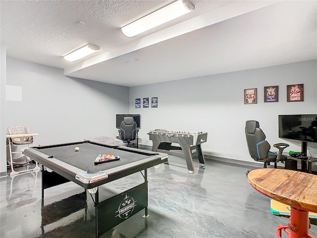 recreation room with concrete floors and a textured ceiling