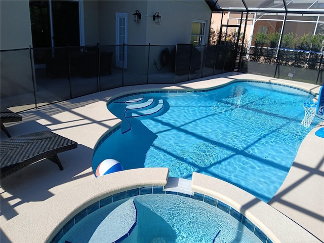 view of swimming pool featuring a lanai and a pool with connected hot tub