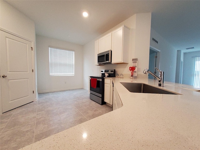 kitchen featuring light tile patterned flooring, appliances with stainless steel finishes, sink, and white cabinets