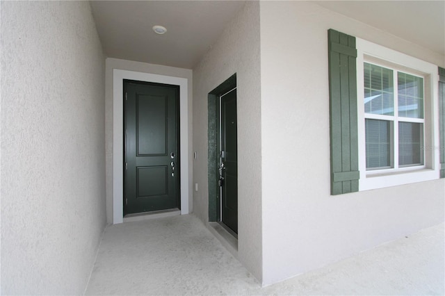 doorway to property featuring stucco siding