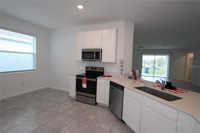 kitchen with a sink, stainless steel appliances, a healthy amount of sunlight, and white cabinets