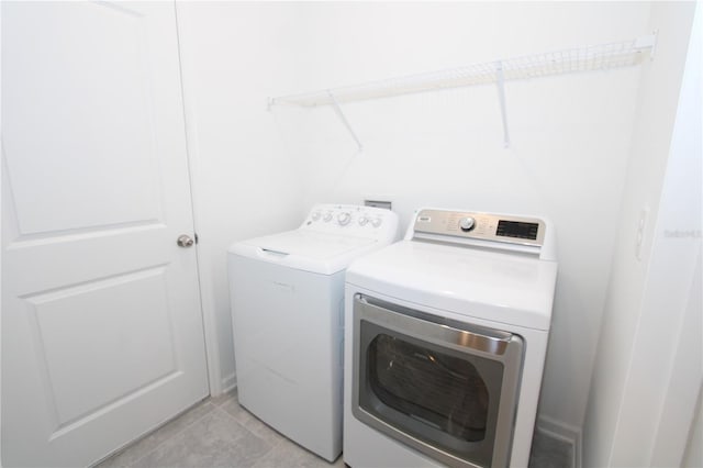 clothes washing area with laundry area, light tile patterned floors, and independent washer and dryer