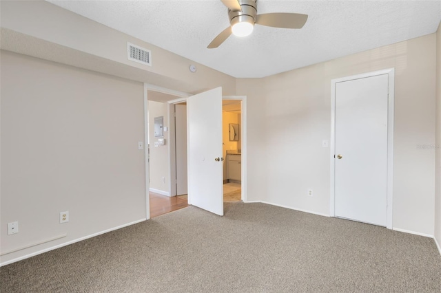 unfurnished bedroom with ceiling fan, a textured ceiling, and carpet