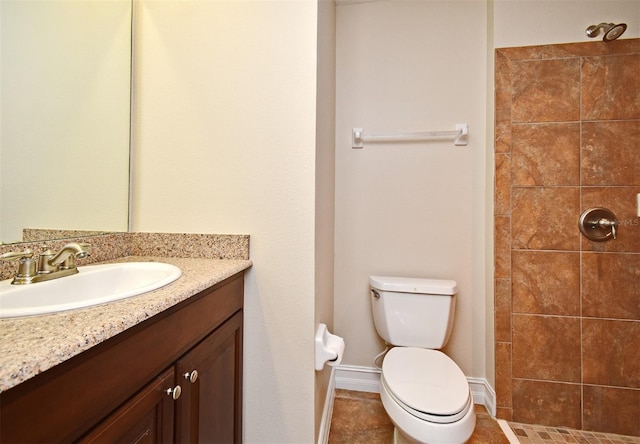 bathroom featuring tiled shower, vanity, and toilet