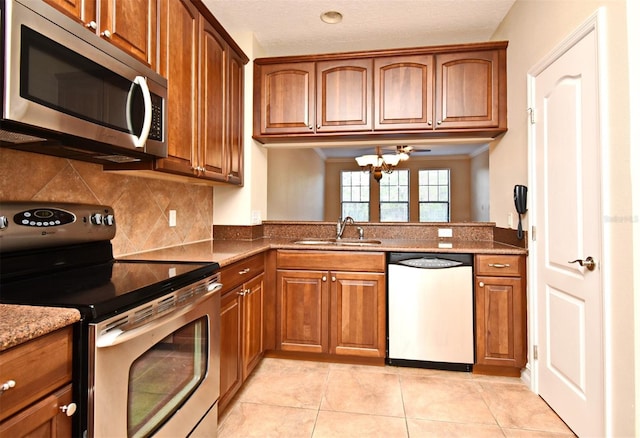 kitchen featuring light tile patterned floors, sink, appliances with stainless steel finishes, dark stone countertops, and tasteful backsplash