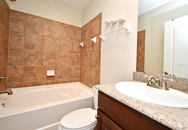 full bathroom featuring vanity, tiled shower / bath, and toilet