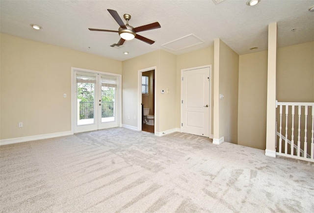 carpeted spare room featuring french doors and a textured ceiling