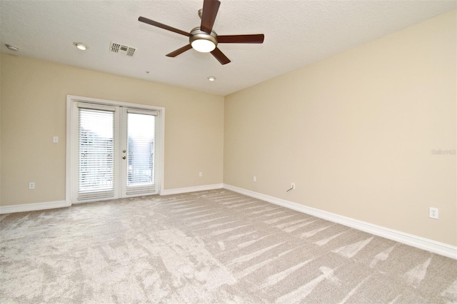 carpeted spare room with ceiling fan, french doors, and a textured ceiling