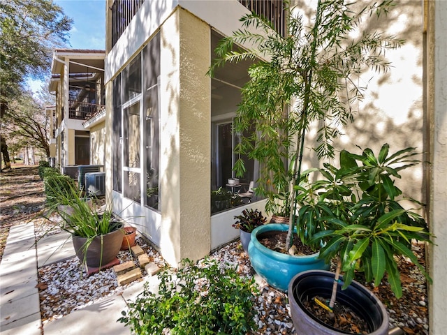 view of side of property featuring a sunroom and stucco siding