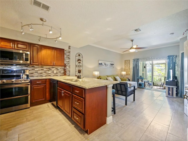 kitchen featuring appliances with stainless steel finishes, backsplash, visible vents, and a peninsula