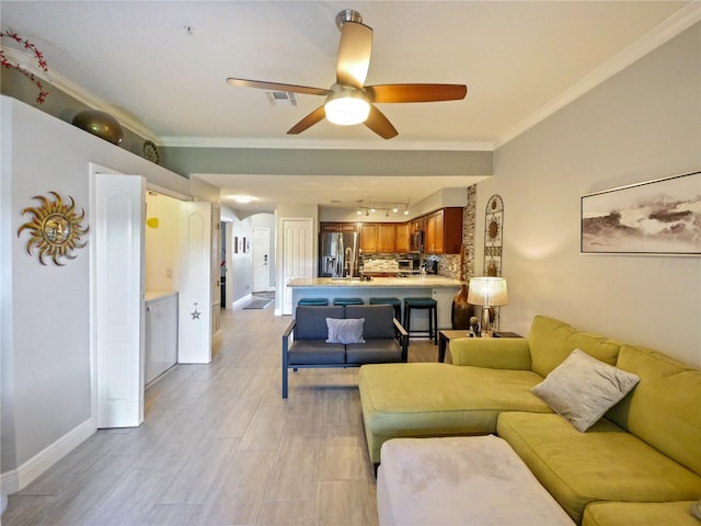 living room with a ceiling fan, baseboards, visible vents, and crown molding