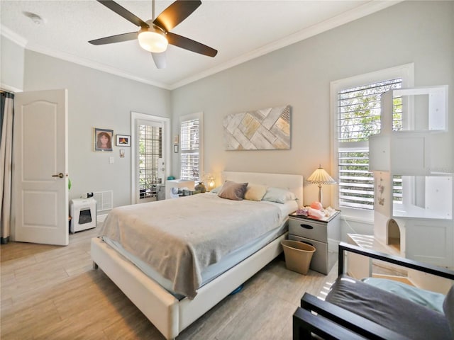 bedroom with light wood-type flooring, visible vents, a ceiling fan, and ornamental molding