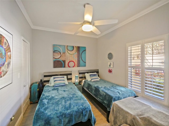 bedroom with crown molding, ceiling fan, and wood finished floors