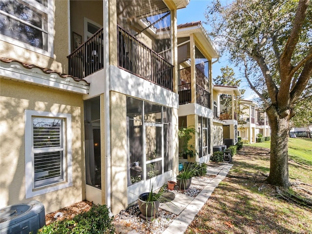 view of home's exterior with stucco siding and central AC unit