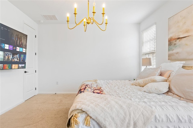 carpeted bedroom featuring an inviting chandelier