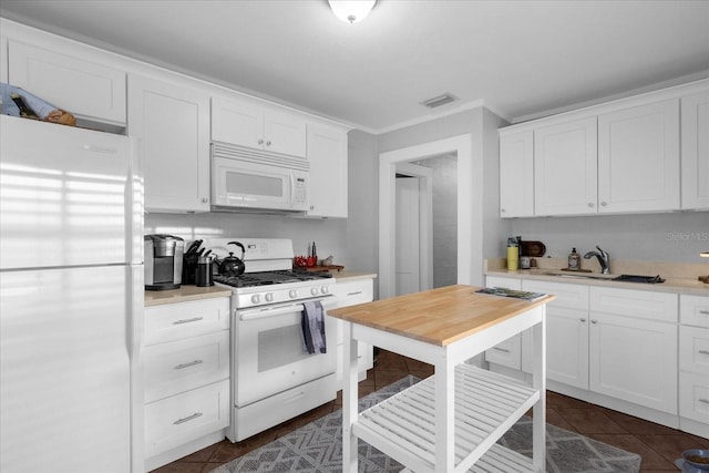 kitchen with white cabinetry, white appliances, sink, and dark tile patterned floors