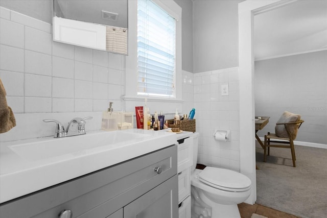 bathroom with tile walls, vanity, and toilet