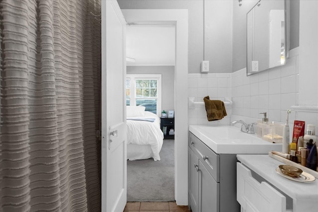 bathroom with tile patterned flooring, vanity, and tile walls