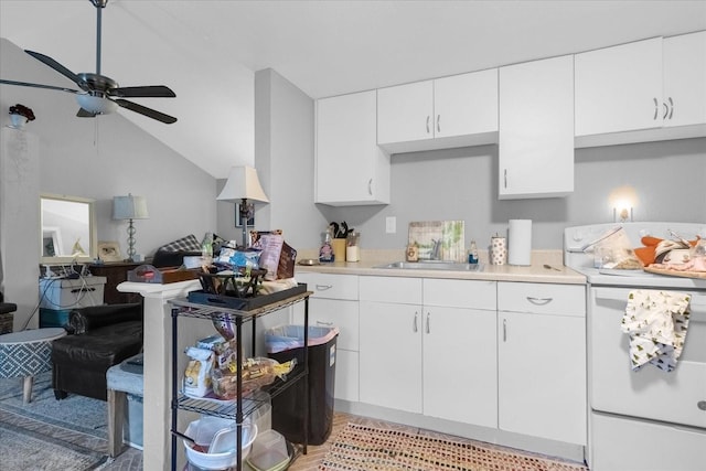 kitchen featuring lofted ceiling, sink, white cabinets, electric range, and ceiling fan