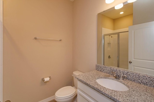 bathroom with vanity, a shower with door, and toilet