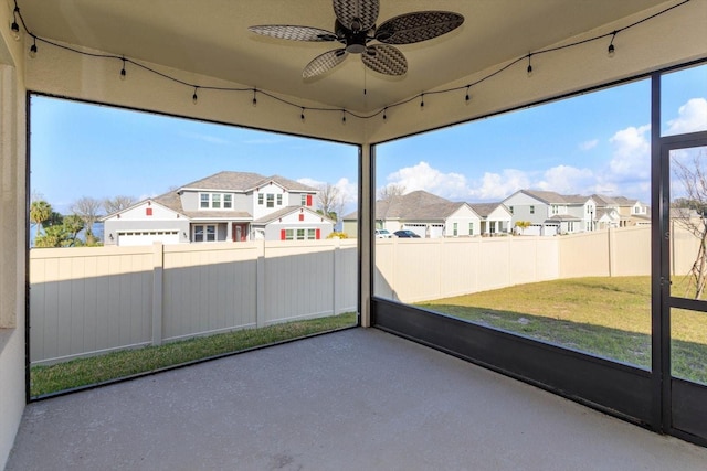 unfurnished sunroom featuring ceiling fan