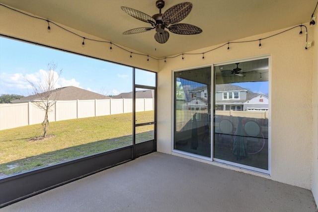 unfurnished sunroom with ceiling fan