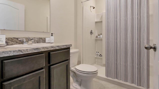 bathroom featuring vanity, tile patterned flooring, a shower, and toilet