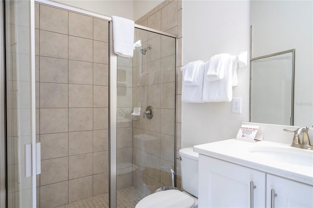 bathroom with walk in shower, vanity, and toilet