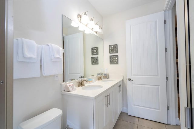 bathroom with tile patterned flooring, vanity, and toilet