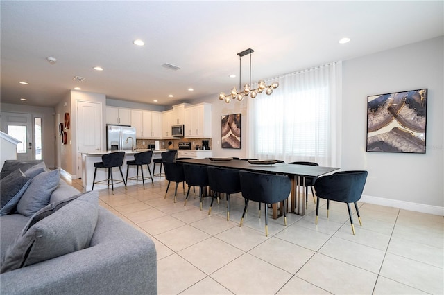 dining space with a healthy amount of sunlight, light tile patterned floors, and a notable chandelier