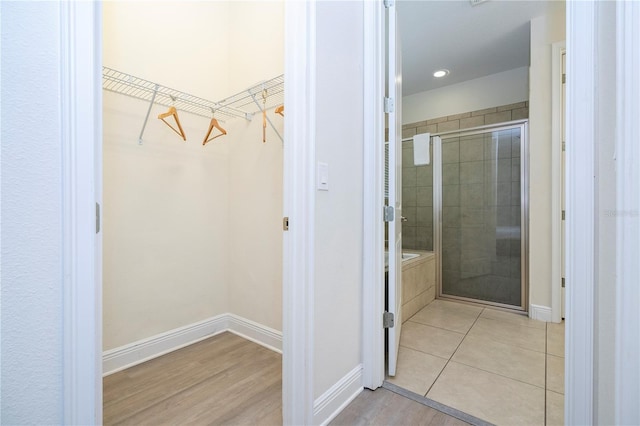 bathroom featuring an enclosed shower and wood-type flooring