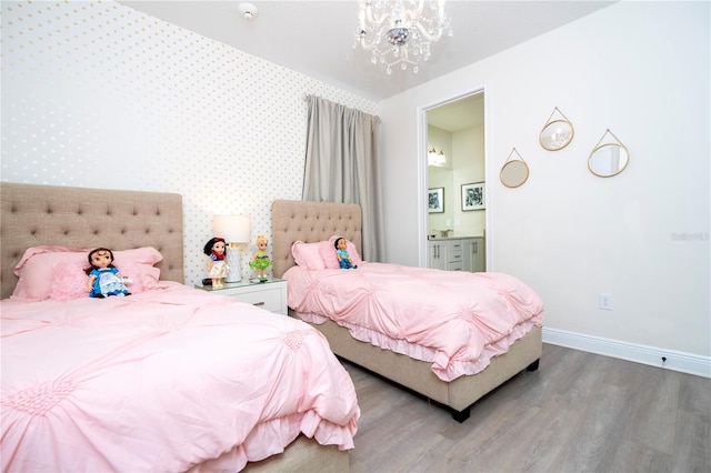 bedroom featuring ensuite bath, wood-type flooring, and a chandelier