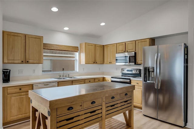 kitchen with stainless steel appliances, lofted ceiling, sink, and light hardwood / wood-style flooring