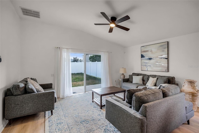 living room with ceiling fan, light hardwood / wood-style floors, and vaulted ceiling