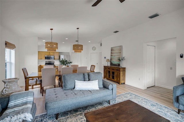 living room with light hardwood / wood-style flooring and ceiling fan