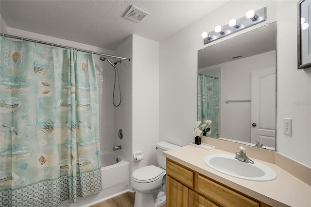 full bathroom with shower / bath combination with curtain, vanity, toilet, and a textured ceiling