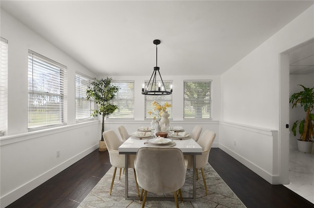 dining area with a notable chandelier, dark wood finished floors, and baseboards