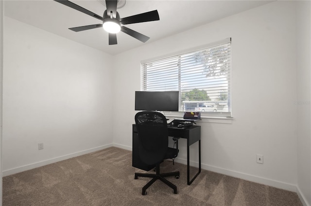 carpeted office space featuring ceiling fan and baseboards