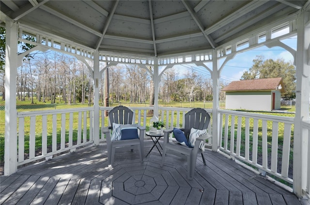 wooden terrace featuring a gazebo and a lawn