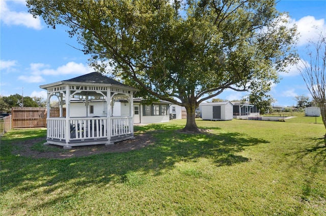 view of yard with an outbuilding, fence, a gazebo, and a storage shed