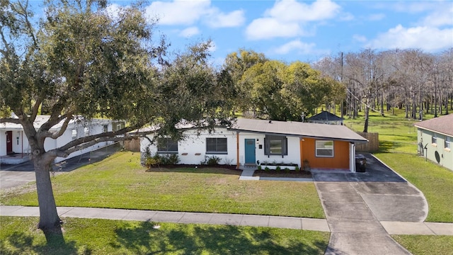 view of front facade featuring driveway, a front lawn, and fence