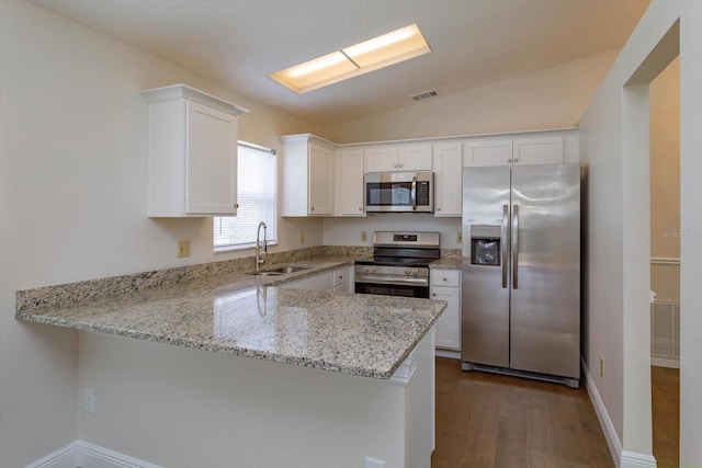 kitchen featuring stainless steel appliances, sink, white cabinets, and kitchen peninsula