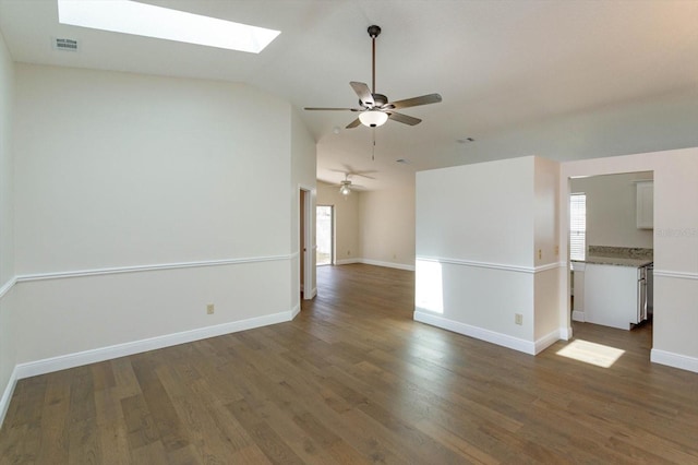 unfurnished room with vaulted ceiling with skylight, a wealth of natural light, and dark hardwood / wood-style flooring