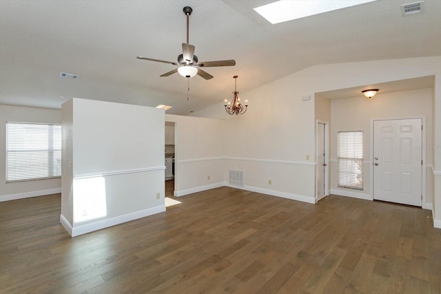 unfurnished living room with ceiling fan with notable chandelier, dark wood-type flooring, and vaulted ceiling