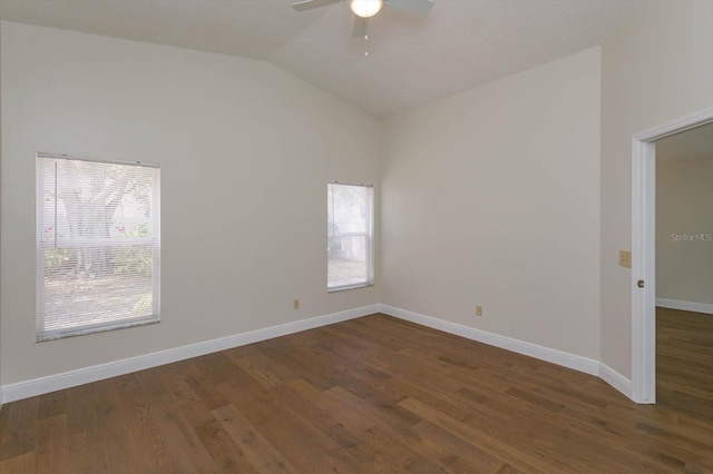 empty room featuring vaulted ceiling, dark hardwood / wood-style floors, and ceiling fan