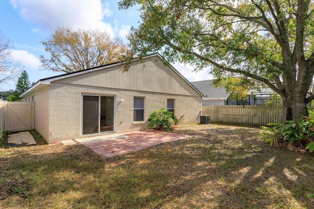 rear view of property featuring cooling unit, a yard, and a patio